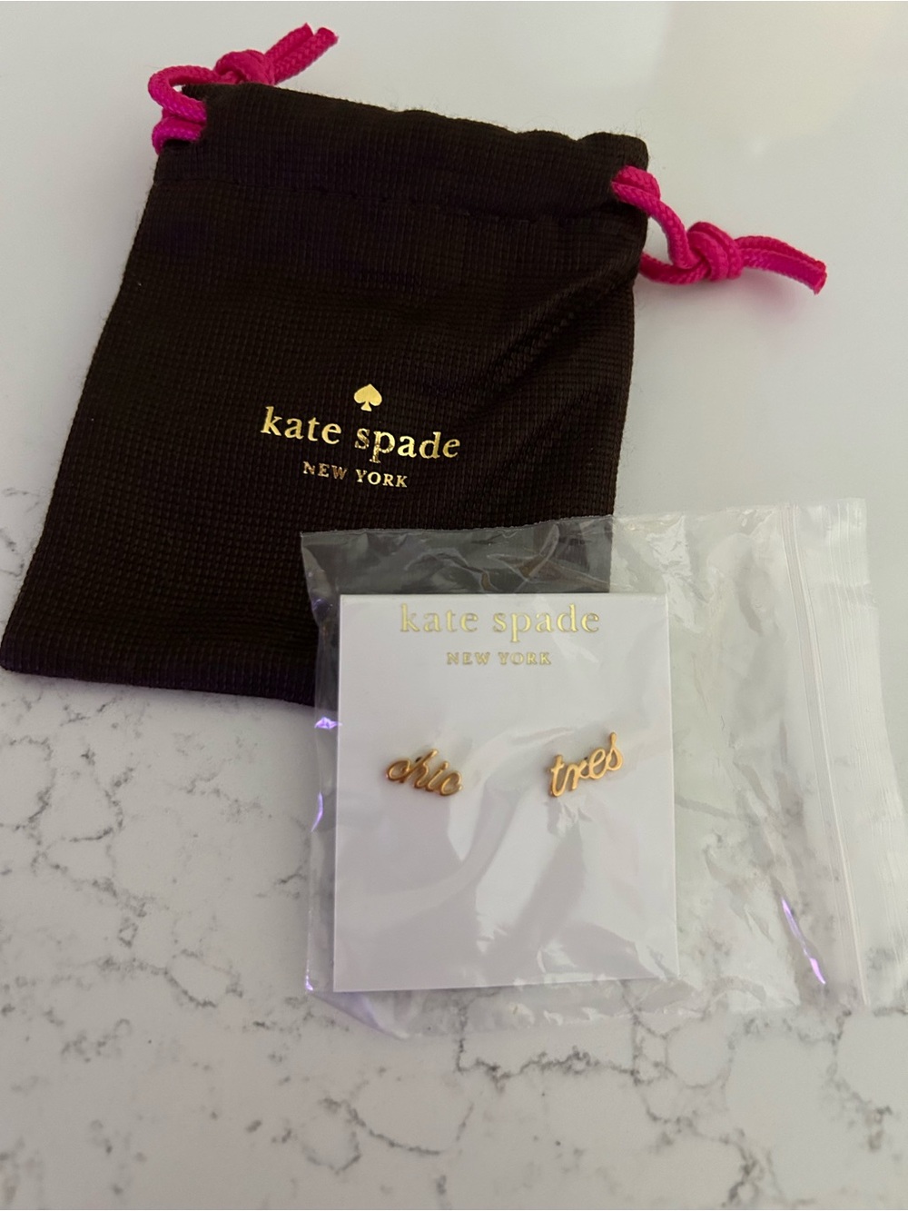 Kate Spade gold script stud earrings. Small Kate spade bag included.
Never worn.